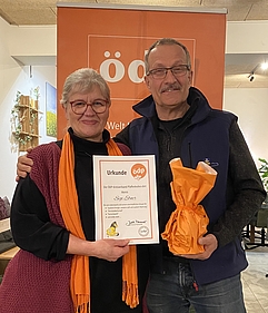 Die Kreisvorsitzende Judith Neumair überreicht Sigi Ebner ein kleines Geschenk und eine Urkunde